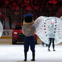 Louie watching Alumni play a game on the ice together at the Detroit Red Wings GVSU Night